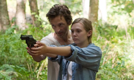Martha Marcy May Marlene film still showing two people in the woods with a gun