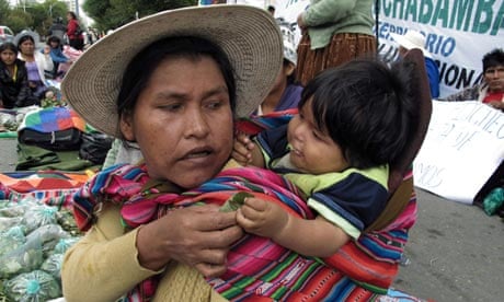 Bolivian woman gives her baby coca leaves
