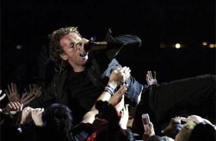 Chris Martin of Coldplay singing while stage diving