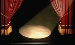 A Stage With A Spotlight And Drawn Curtains