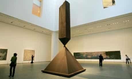 Visitors walk around a sculpture by Barnett Newman entitled Broken Obelisk, on display at MoMa