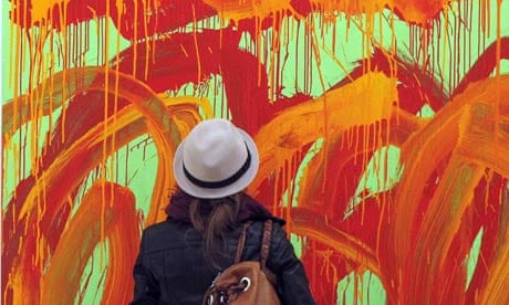 A woman takes in a painting by Cy Twombly