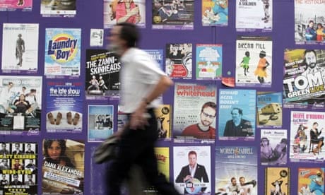 A man walks in front of Edinburgh festival posters