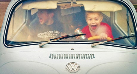 Two boys playing in a Beetle car