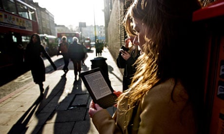 Woman reads ebook, Kindle in street