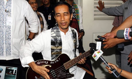 Jakarta governor Joko Widodo holding a bass guitar gifted to him by Robert Trujillo of Metallica