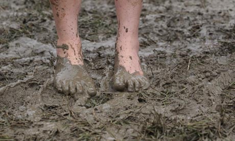 A festival-goer braves the mud at Glastonbury 2011