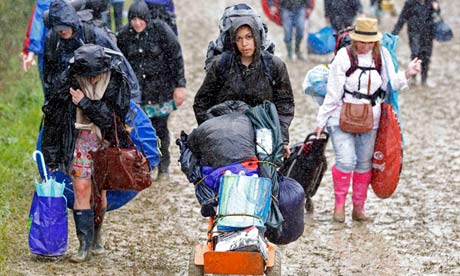 Glastonbury 2011 festival goers push their belongings through the mud