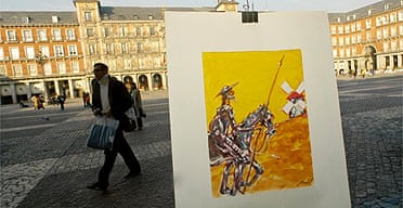 A man walks past a street painter's portrait of Don Quixote in Madrid
