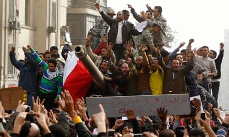 Demonstrators on an army tank in Tahrir square during protests in Cairo