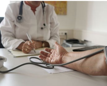 Doctor takes patients blood pressure-detail