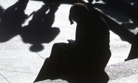 A woman checks a mobile device during a lunch break in London
