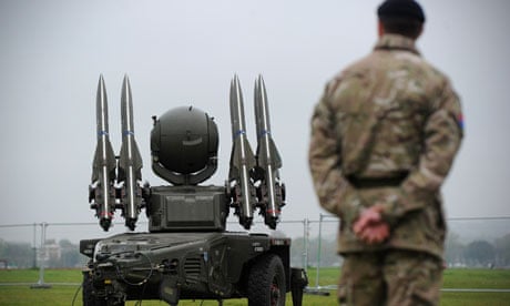A soldier stands beside a Rapier missile defence system