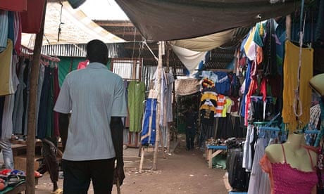 A man walks in a market stalls selling secondhand clothes in Juba