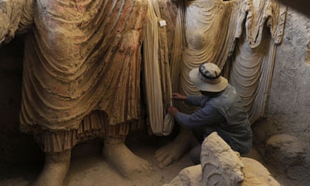 An Afghan archaeologist examines the remains of statues of Buddha at Mes Aynak.