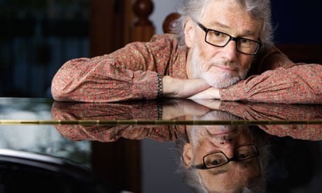 Iain Banks leaning on a grand piano