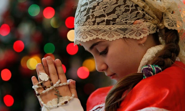 Holy fire … an Iraqi Christian girl prays in a Chaldean church in neighbouring Jordan