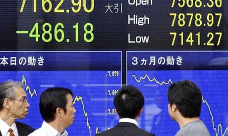 People look at stock prices in Tokyo, Japan