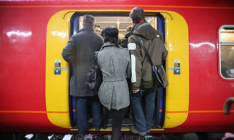 commuters squeeze on to crowded Train at Clapham Junction 