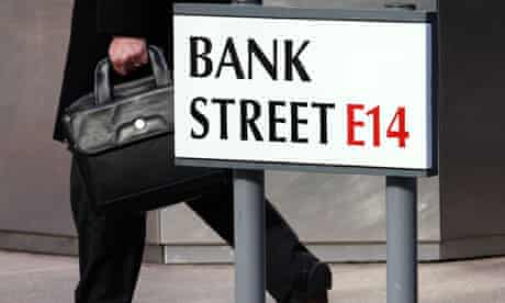 A worker passes a sign for Bank Street in Canary Wharf in London