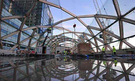 Builders work on a roof above the Canary Wharf Crossrail station
