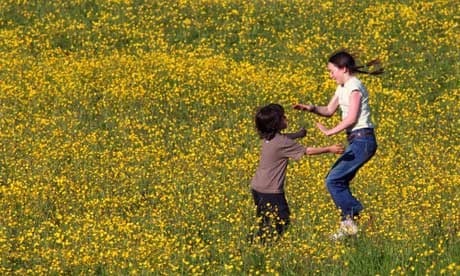 Children playing in a field of buttercups