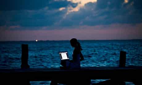Woman with laptop on pier