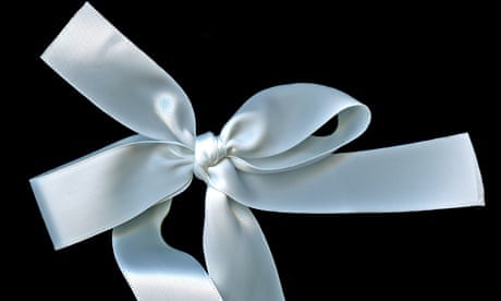 White ribbon tied in a bow on black background