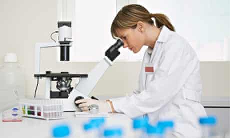 Female scientist using microscope in laboratory
