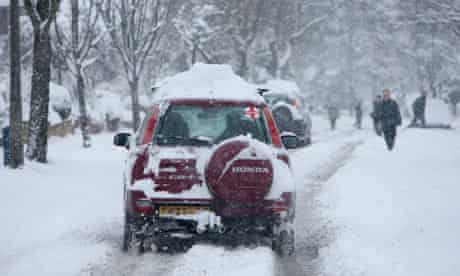 A car drives through the snow in Carshalton