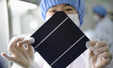 An employee displays a solar panel at Chint Solar  factory in Hangzhou, China