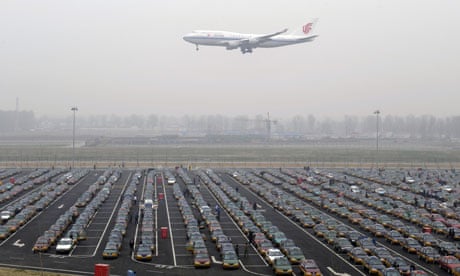 Tele-reduction of carbon in China : An Air China jetliner descends to land past rows of taxis