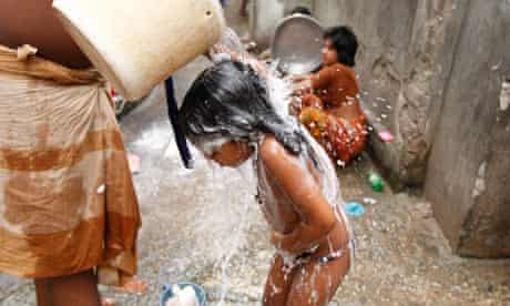 MDG : World Water Day :  A Bangladeshi man baths his child in Dhaka, Bangladesh