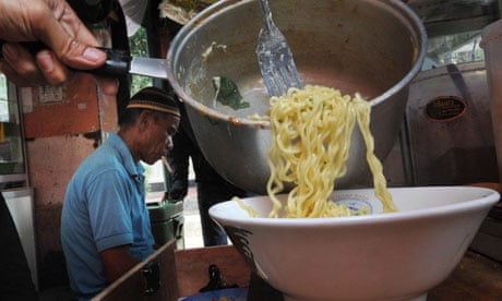 MDG : Food security in Indonesia , a street vendor prepares instant noodles in Jakarta 
