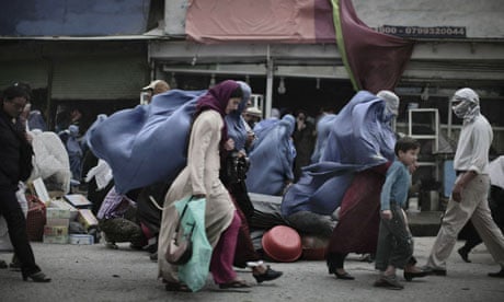 Burqa-clad MDG : Women in Afghanistan : Afghan women walk against the wind  in central Kabul