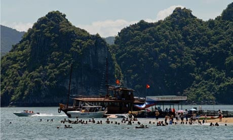 Tourists flock a tiny beach on the edge of a stone island of Halong Bay, Ha long Bay
