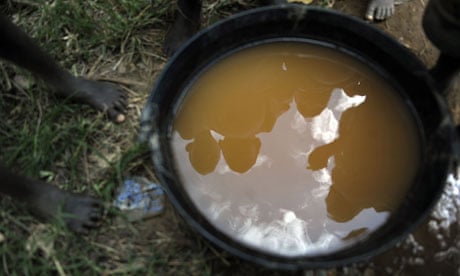 MDG : Water :  children reflected in a pail of murky water fetched from a well
