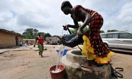 MDG : Access to water  : A woman draws water from a water well