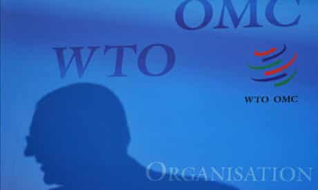 MDG : WTO : A silhouette of an official is seen with a logo of the World Trade Organization