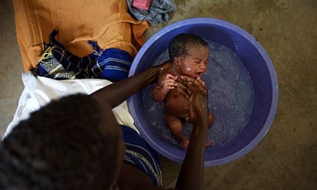 MDG : A baby is washed in a bowl in Uganda