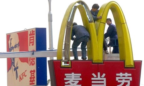 MDG :  Chinese workers install lights on a McDonald's sign in Beijing