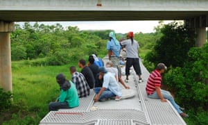 MDG : 2013 UN Report on Migration : Several migrants travel on top of a train in Mexico