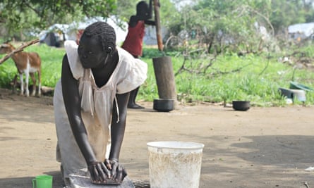MDG a woman grinds grain in South Sudan