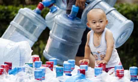 Children of the revolution ... water bottles are brought in to a housing complex in Beijing, China.