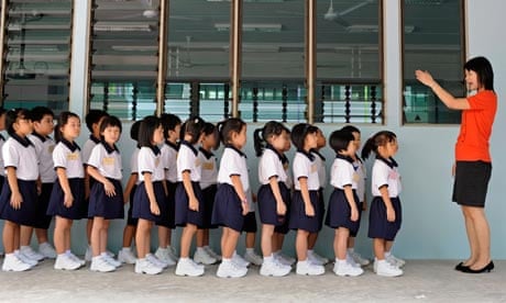 A primary school teacher in Singapore gets her pupils to line up on the first day of the school term