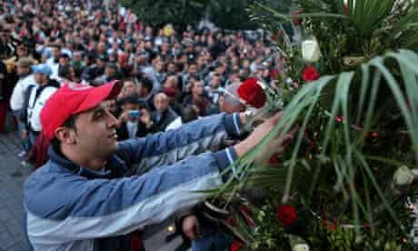 A Tunisian man puts flowers as a tribute 