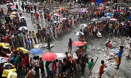 Victims of Typhoon Haiyan queue for food and water in Tacloban city