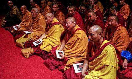 Buddhist monks listen as the Dalai Lama speaks to an audience in New York City