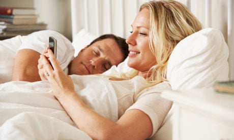 Woman Using Mobile Phone In Bed