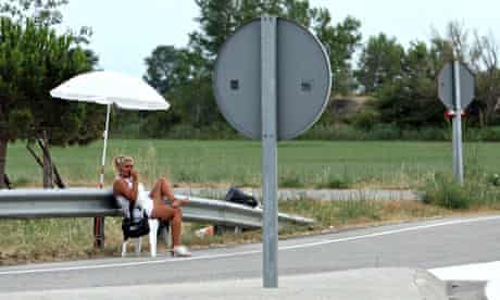 MDG : EU prostitution new law : prostitute sitting on a chair waiting on a road